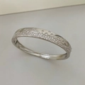 Close-up of silver open bangle with pavé-set colorful zircons and polished finish - Silver (White Rhinestone)