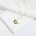 Raffinata collana a farfalla dorata con smalto verde e beige su uno sfondo di seta bianca - Farfalla Verde