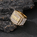 Gros plan de la bague KING plaquée or avec cristaux sur fond de roche noire texturée - Doré / US 7