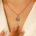 Dettaglio di collana a conchiglia dorata con onde marine in smalto blu su una modella - Collana con Ciondolo Rotondo Onda Stella Luna Dorata (Tono Oro 10K Onda 5931)