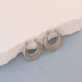 Detailed macro view of silver oval hoop earrings with unique radial swirl texture - Silver Radial Vortex Crescent
