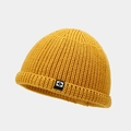 Gros plan détaillé d'un bonnet en maille jaune vif avec écusson N et texture épaisse - Jaune