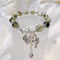 Green crystal bead bracelet with silver fish and lucky cat pendants on white fabric - Green Ghost: Lucky Koi and Lotus Leaf Fortune Cat Bracelet