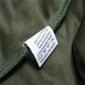 Macro shot of 100% polyester fabric texture and wash care label on green sports shorts - Army Green (Detail 4)
