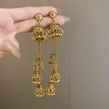 Close-up of vintage golden multi-layer Jhumka earrings with bell tassel details - Wind Chime Tassel Drop / Gold