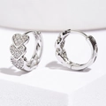 Polished silver heart hoop earrings with micro-pave cubic zirconia on white pedestal - Silver
