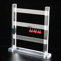 Makroaufnahme von 3-stufigem Acryl-Ohrringständer mit roten Perlenohrringen - Dreilagig / Transparent