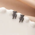Close-up of black metal pug puppy stud earrings with hollow heart pattern details - Cute Dog with Heart (785) / Black