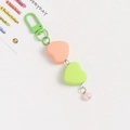 Detail of sweet heart charms in orange and green with pink bead on metal keychain - Orange and Green Hearts