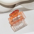 Detail of square amber translucent plastic hair claw clip with sharp directional shadows - Square Orange