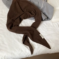 Detailtextur eines dunkelbraunen Strickschals mit minimalistischem Markenetikett - Kaffeebraun