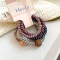 Macro detail of five spiral telephone wire hair ties with beads on a branded display card - Coffee Set (Five Pieces)
