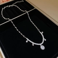 Macro detail of silver necklace with zircon, pearls, and snowflake charms in velvet box - Necklace-Silver-Flower