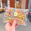 Close-up of colorful plush elastic hair bands in a transparent daisy branded package - Light Color Plush 100pcs