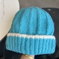 Vue détaillée du bonnet en tricot bleu avec bord blanc roulé et texture douce d'hiver - Bleu