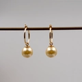 Vista dettagliata di eleganti orecchini con grandi perle dorate e ganci a cerchio d'oro - Orecchini / 12mm / Oro