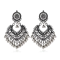 Detail of silver hollowed heart earrings with bells and intricate bohemian patterns - Antique Silver