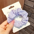 Detail of light purple pleated scrunchie with Sweet Girl display card held by hand - Solid Purple