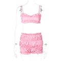 Detailed view of pink satin two-piece sleepwear set with ruffled camisole and matching shorts - Light Pink