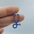 Silver stethoscope brooch with blue enamel detail held in hand, medical pin accessory - Silver Base Blue