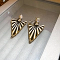 Macro shot of retro geometric earrings with black and white stripes and gold trim - Silver Needle-Black-White