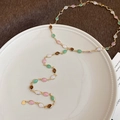 Macro shot of gold necklace with colorful oval gemstones on a white ceramic plate - 29# Necklace Resin Oval Rice Bead Splicing