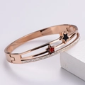 Detailed shot of double-layered rose gold bracelet with star charms and zircon inlay - Rose Gold