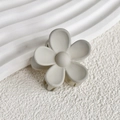 Nahaufnahme einer matten beige Blumen-Haarklammer mit minimalistischem Fünf-Blatt-Design - Grau