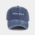 Close-up of white STAY WILD embroidery on vintage washed blue cotton baseball cap - Adjustable / Navy Blue