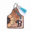 Porte-clés en cuir avec tournesol, lettre B et pompon décoratif bleu ciel - Lettre B