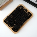 Bulk pack of 50 thick black elastic hair ties neatly arranged on a wooden tray - 50 Pieces / Black