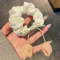 Off-white ruched tulip scrunchie with orange checkered charm and green bow detail - Beige Plaid Tulip Hair Tie