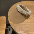 Detailed close-up of straw sun visor with faux pearl embellishments on the brim - Khaki