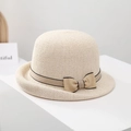 Detailed macro view of cream woven sun hat featuring a khaki ribbon and chic bow - Off White