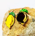 Vista macro di orecchini a forma di limone in acrilico giallo e verde su pietra naturale - Limone (Foglia Verde Gancio Argento)