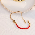 Elegant 18k gold and red woven rope bracelet featuring a round luck pendant - Fu Character Red Rope