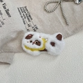 Gros plan d'une broche chat en peluche blanche avec oreilles brodées et détail de foulard - Blanc