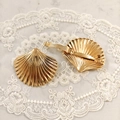 Detailed view of golden scallop hair clips with textured metal surface on lace background - Shell Spring Clip