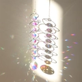 Detail of pink crystal suncatcher with metal spiral frame reflecting rainbow light - AB Color