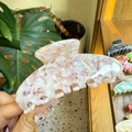 Detailed view of large pink marble acetate hair claw clip held in hand for hair styling - Large / White Shell