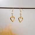 Orecchini a cuore martellato dorato con perle d'acqua dolce su un supporto minimalista - Orecchini