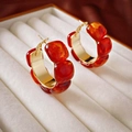 Detail view of red resin and gold C-shaped flower earrings in a beige jewelry gift box - Red-Gold Blocky Hoop