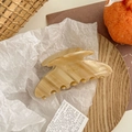 Gros plan sur la pince à cheveux en acétate marbré beige avec lettrage Barrette La France - Beige