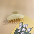 Close-up of a cream-colored glitter acrylic hair claw clip for elegant bun styling - Yellow