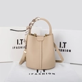 Close-up of beige lychee grain leather bucket bag with silk scarf handle detail - Milky Apricot