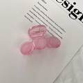 Detalle de pinza para el cabello rosa de acrílico con muelle sobre fondo de papel blanco - Rosa Transparente