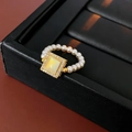 Detailed close-up of a 18k gold pearl ring with a square mother-of-pearl centerpiece - 19 Ring-Gold-White