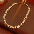 Close-up of gold chain necklace with square zirconia links on brown leather surface - Necklace - Gold