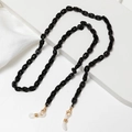 Macro shot of black acrylic eyewear chain with gold lobster clasps and non-slip rubber loops - Black