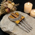 Macro shot of tiger eye crystal hair pin with silver crescent moon on a stone - Tiger's Eye
